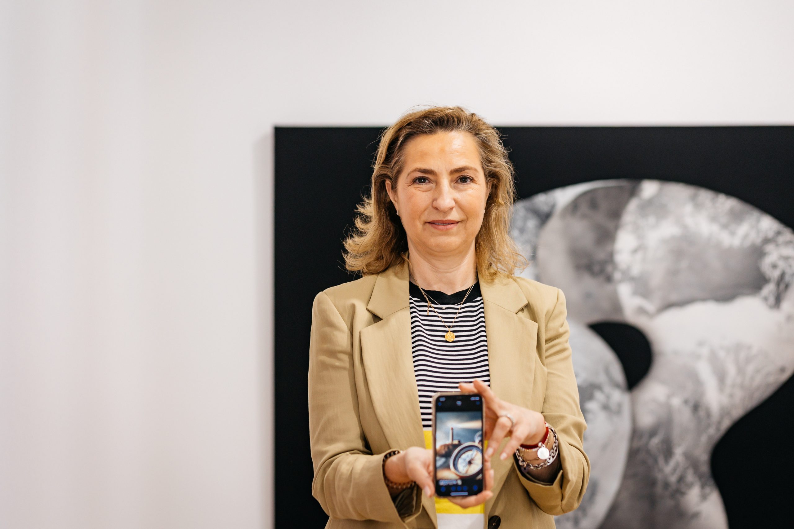 Carmen Moreno en la galería de arte sosteniendo su móvil